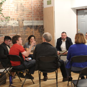 A group of people in conversation during a monthly forum